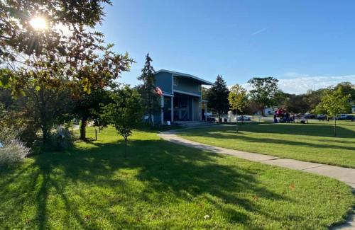 Blue bandshell in front of open green space and trees