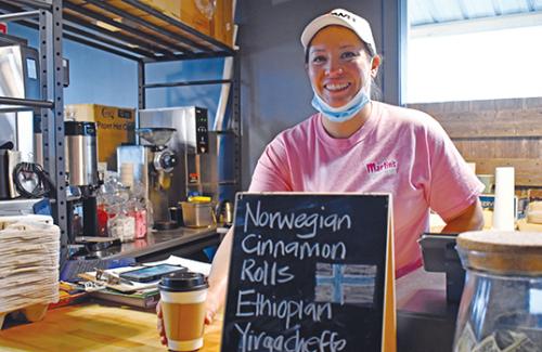 Smiling woman behind counter of cafe