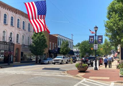 Downtown Buchanan in the summer with a large american flag hanging over the venter of the street