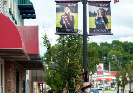 Downtown Buchanan MI, black lightpost with two banners showing high school band members