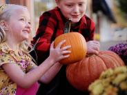 Two girls holding pumpkins