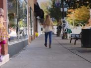 Little girl jumping off the step of a local business