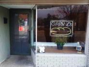 Storefront - exterior of a brick building with a neon sign that says Gary Z's