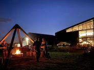 Exterior of a large modern building and a firepit at night