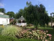Image of a white gazebo in summer and a butterfly garden in bloom 
