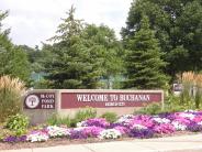 Maroon and white Welcome to Buchanan Sign flanked by landscaped flowers and trees