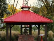 A red roofed structure housing historic firehouse bell
