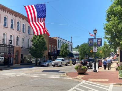 Downtown Buchanan in the summer with a large american flag hanging over the venter of the street