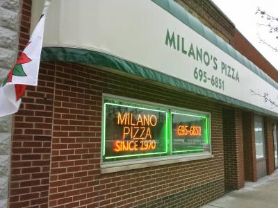 Exterior of a brick building with a sign that says Milano's Pizza